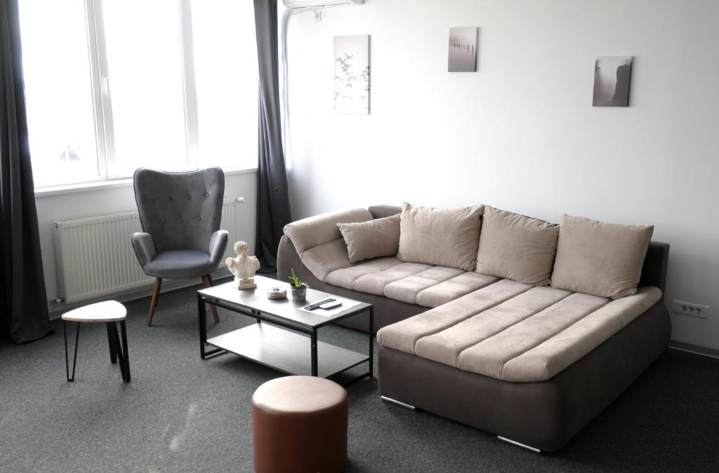 a living room with a couch and a chair at Luana Airport Apartments #3 in Otopeni