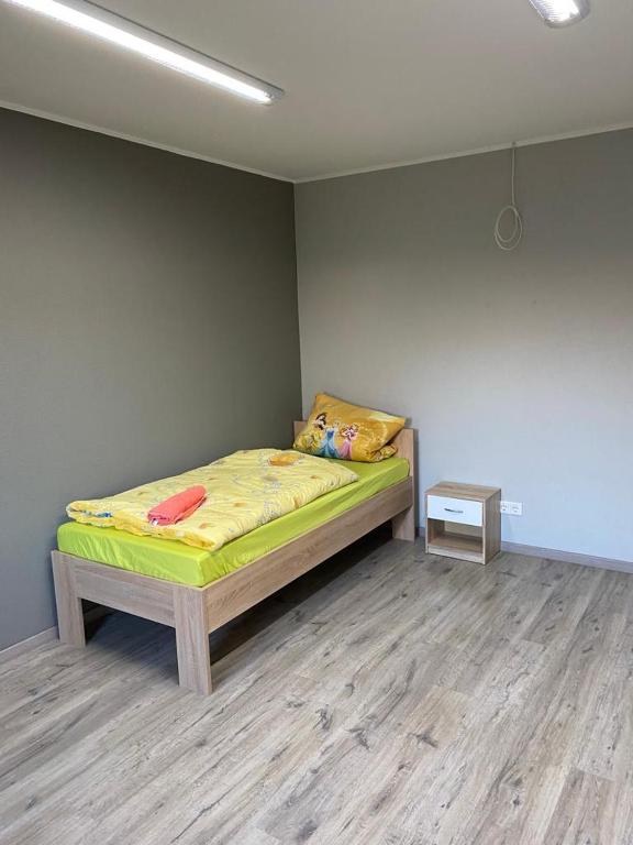 een slaapkamer met een bed met een gele sprei en een tafel bij MZ Zimmervermietung 