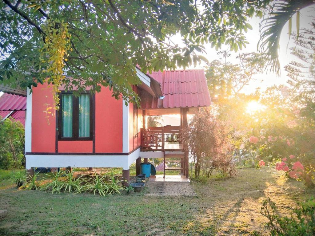 a house with a red roof in a forest at Three Monkeys Bungalows Koh Yao Noi in Ko Yao Noi