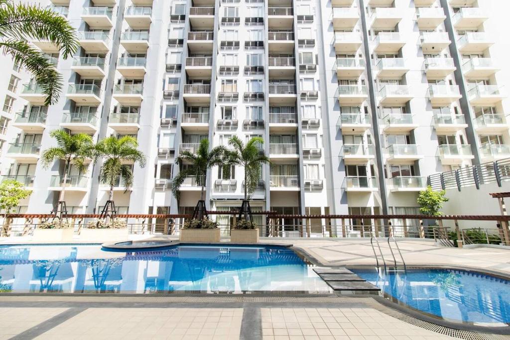 a swimming pool in front of a large apartment building at 2 BR Condo Apartment near NAIA 3 Pasay City in Manila