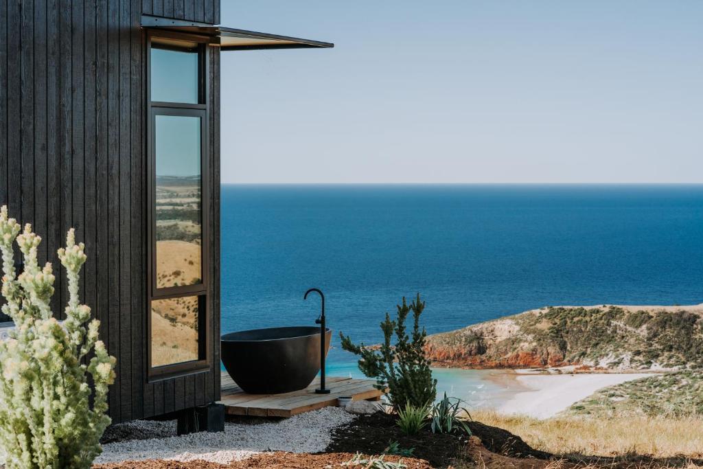a bathroom with a tub and a view of the ocean at Wander on Kangaroo Island in Stokes Bay