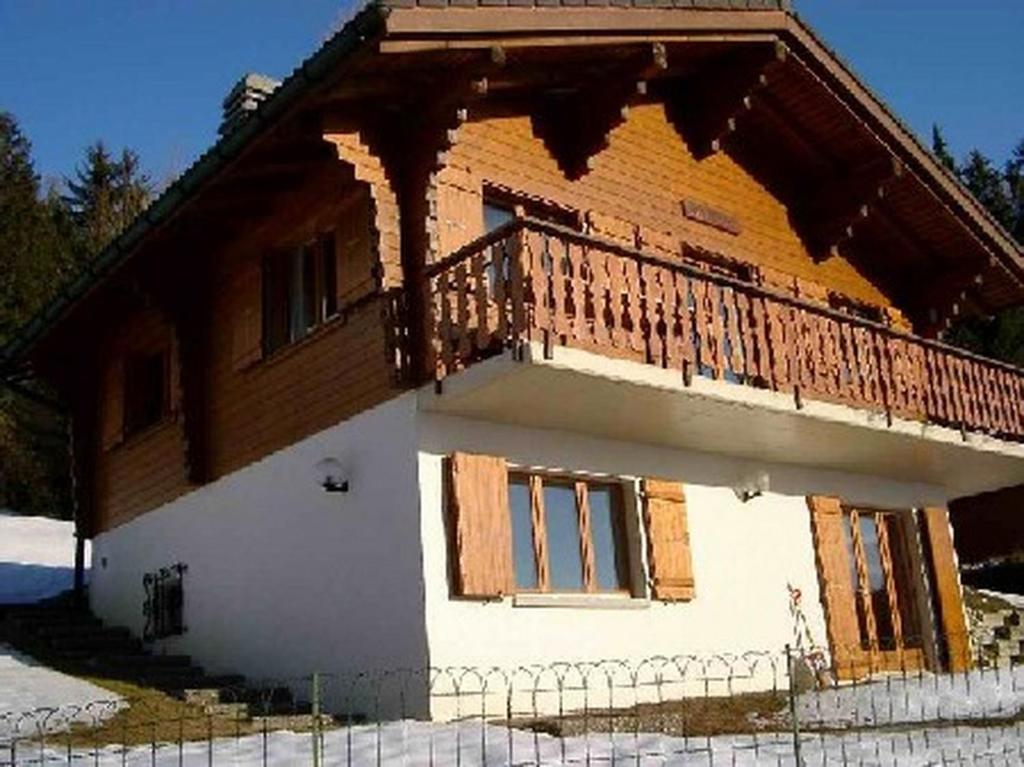 a house with a balcony on the side of it at Chalet Solina in Icogne