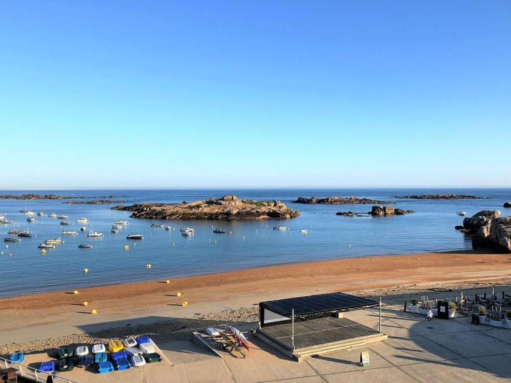 - une vue sur une plage avec des bateaux dans l'eau dans l'établissement Appartement 3* avec balcon et parking face à la plage de Trégastel - FR-1-368-171, à Trégastel