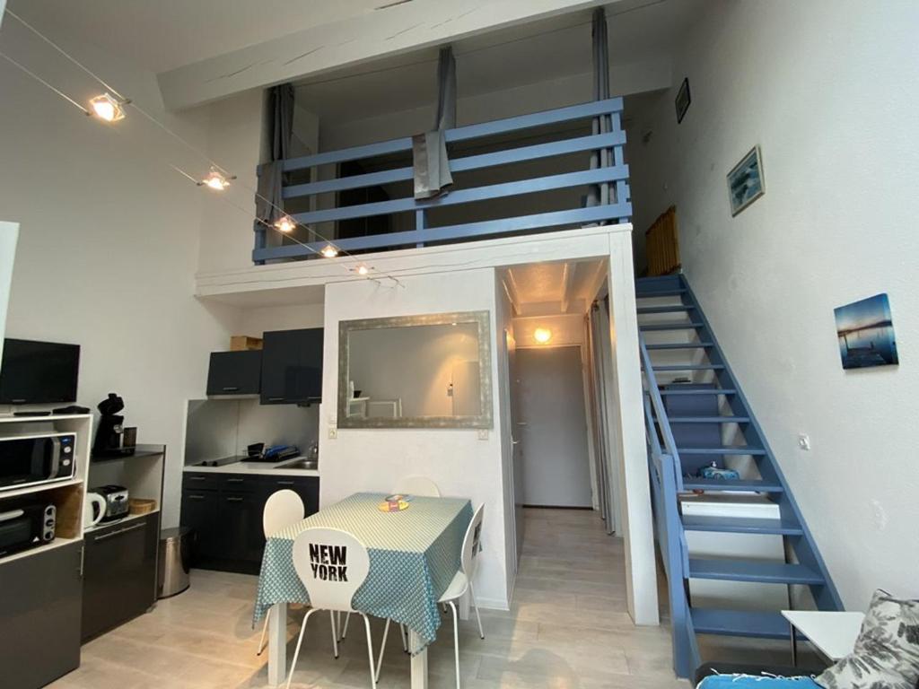 Ce petit appartement dispose d'un escalier, d'une table et d'une chambre. dans l'établissement Appartement avec terrasse, parking et vue sur port à Capbreton - FR-1-413-130, à Capbreton