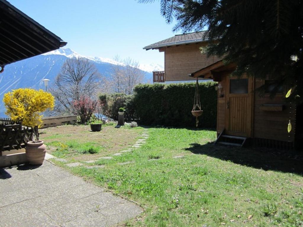 a yard with a house with a mountain in the background at Chalet le Rhône in Mollens