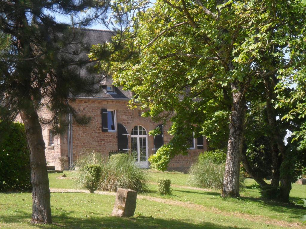 an old brick house with trees in front of it at Gite de Peche in Saint-Ellier-du-Maine