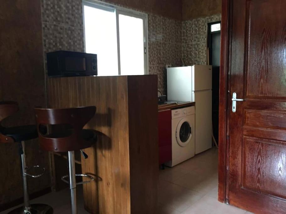 um quarto com uma cozinha com máquina de lavar e secar roupa em May'Nature em Labattoir