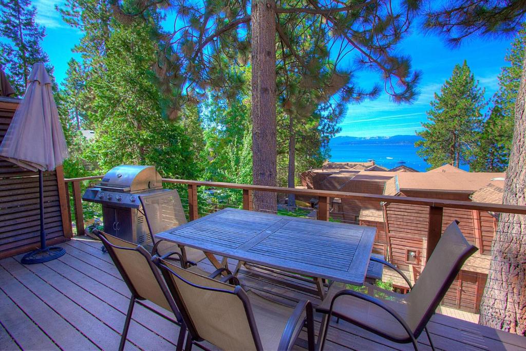 a picnic table and chairs on a deck with a grill at Chipmunk's Paradise condo in Kings Beach