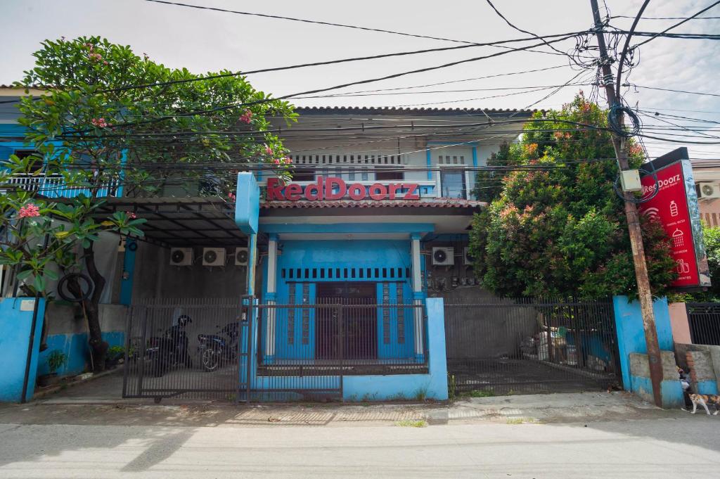 a blue building with a sign on top of it at RedDoorz near Margonda Raya in Kemirimuka Dua