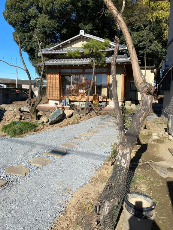 un árbol delante de una casa en 田舎庵 en Hanyu