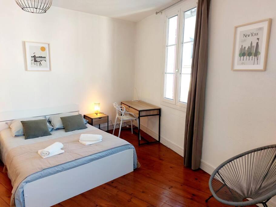 1 dormitorio con cama, escritorio y ventana en T2 de charme, centre ville historique de Tarbes en Tarbes