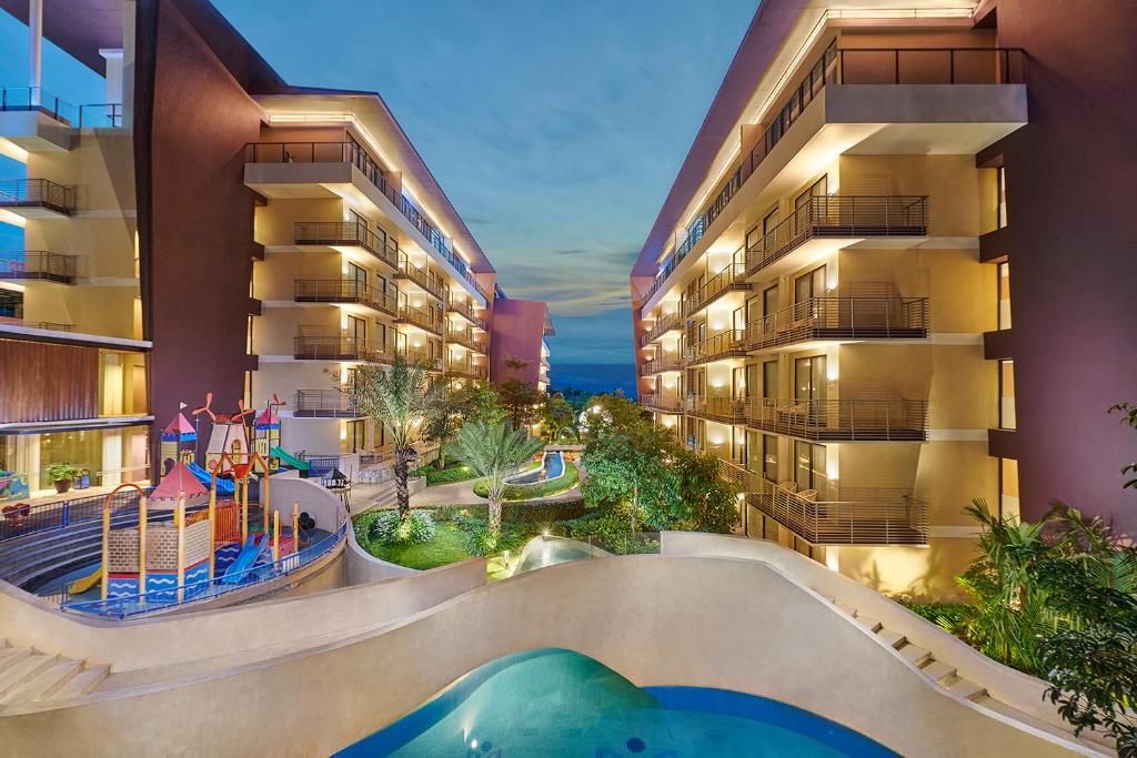 an apartment complex with a pool and a playground at Golden Tulip Holland Resort Batu in Batu