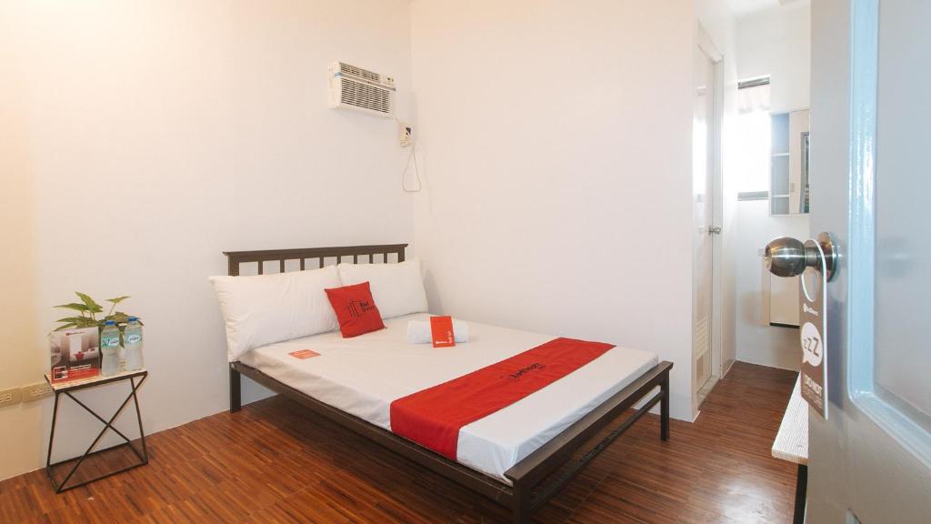 a small bedroom with a bed with a red blanket at Enrico's Place in Manila