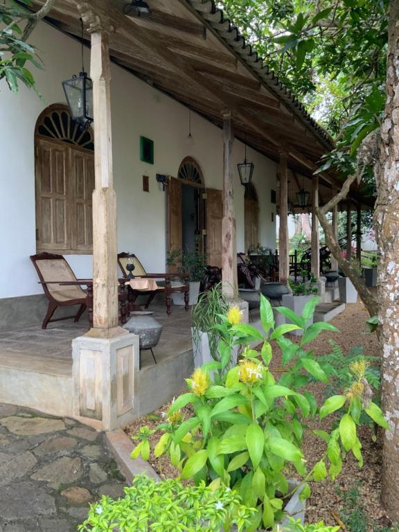 a porch of a house with a table and chairs at Lali Villa & Fruit Garden in Galle