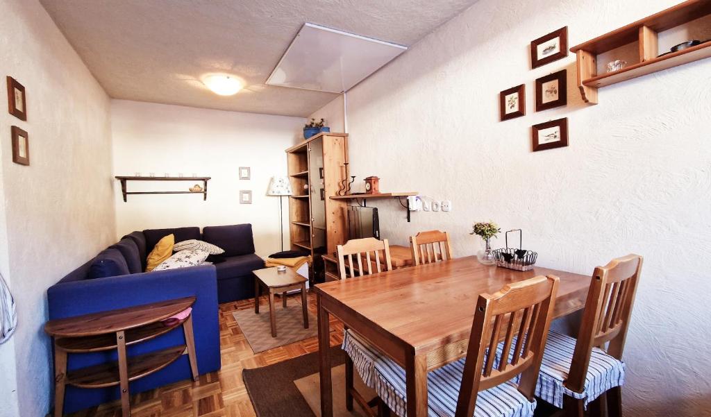 sala de estar con mesa y sofá azul en Apartma Brlog Petra, Kranjska Gora en Kranjska Gora