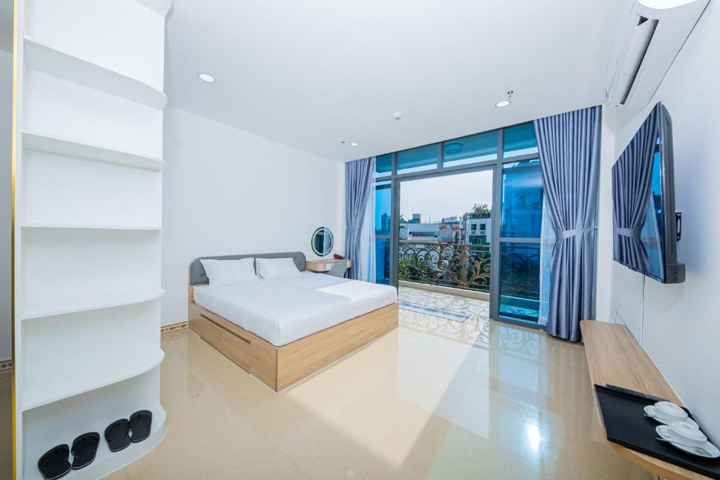 a bedroom with a bed and a large window at Chanh Huy Apartments & Hotel in Ho Chi Minh City