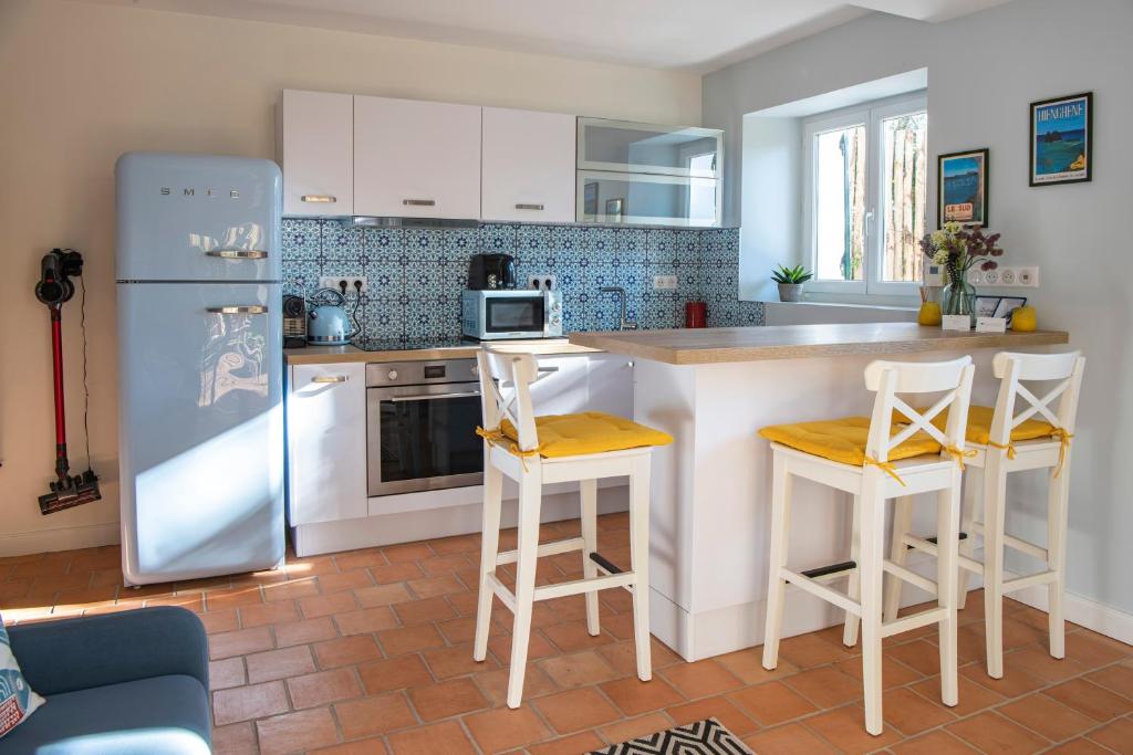 La cuisine est équipée d'un réfrigérateur et de deux tabourets de bar. dans l'établissement Le Petit Bois - A 300m de la plage Pereire, à Arcachon
