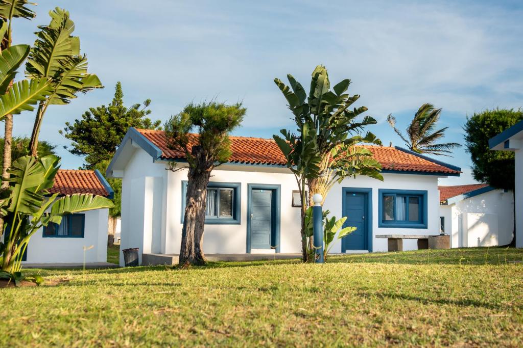 ein Haus mit Palmen davor in der Unterkunft Ponta Mar Resort in Ponta do Ouro