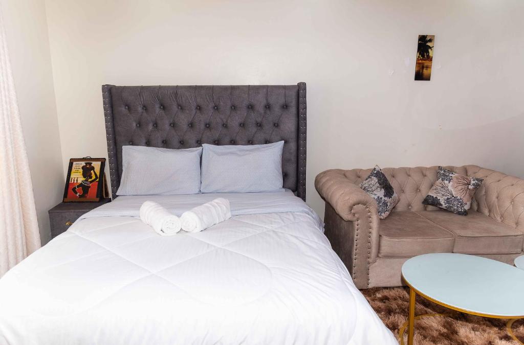 1 dormitorio con 1 cama grande y 1 sofá en SpringStone Studio Apartment Rm 19 en Langata Rongai