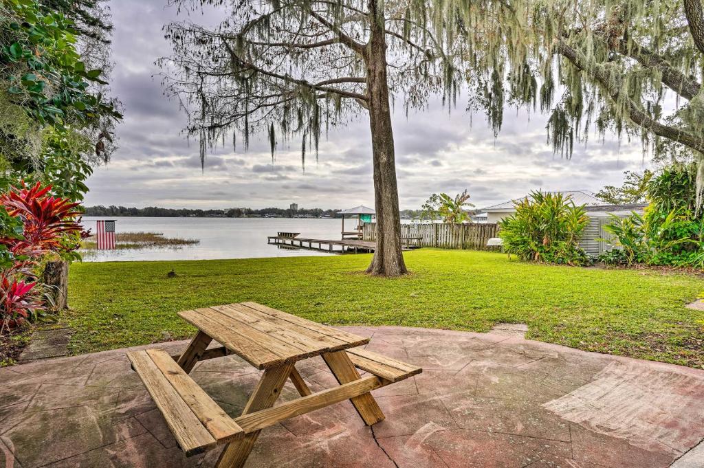 drewniany stół piknikowy siedzący na skale w pobliżu jeziora w obiekcie Waterfront Vacation Rental on Lake Mirror! w mieście Winter Haven