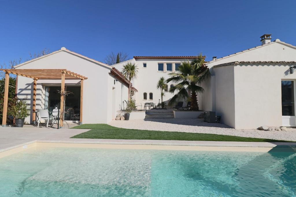 une maison avec une piscine en face d'une maison dans l'établissement Le mas Sainte Marie, à Venasque