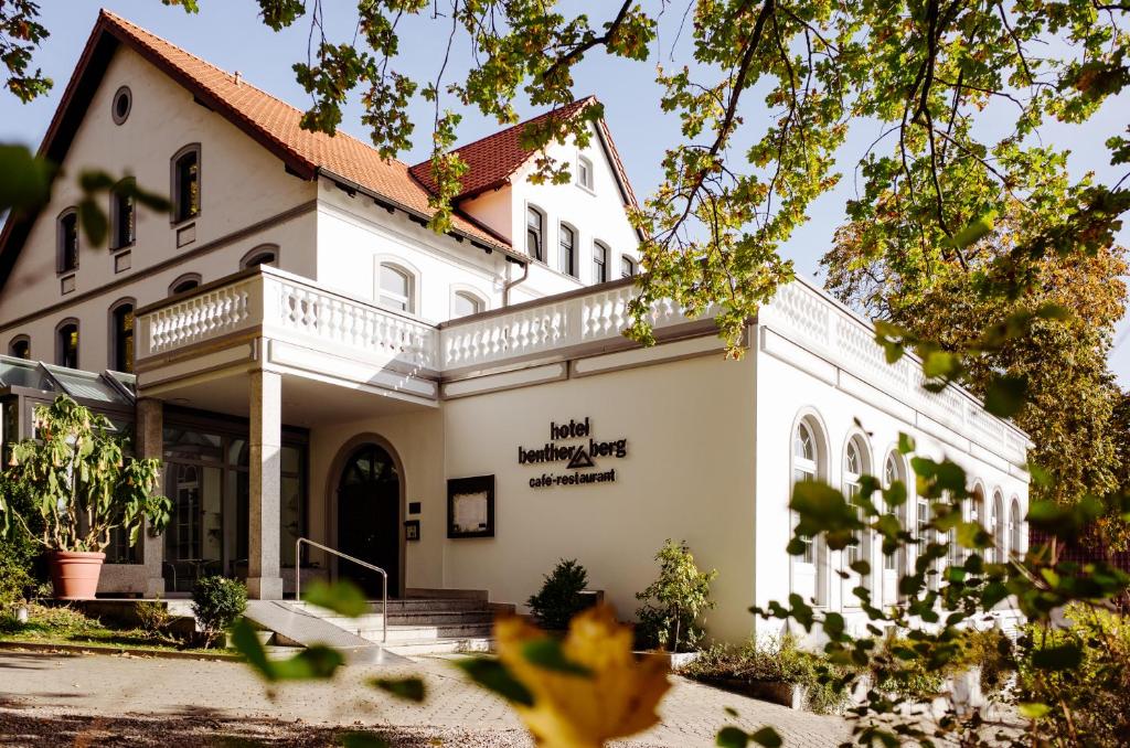 a large white building with a balcony at Hotel Benther Berg in Ronnenberg