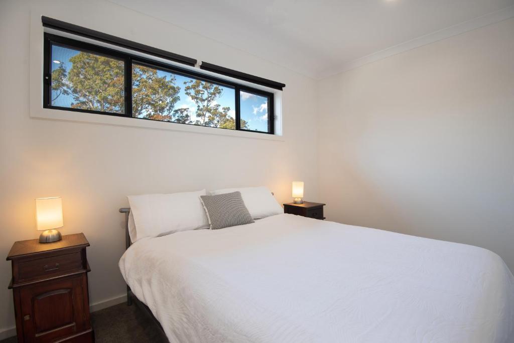 a bedroom with a white bed and a window at Batemans Bay Delight - Pet Friendly in Batemans Bay