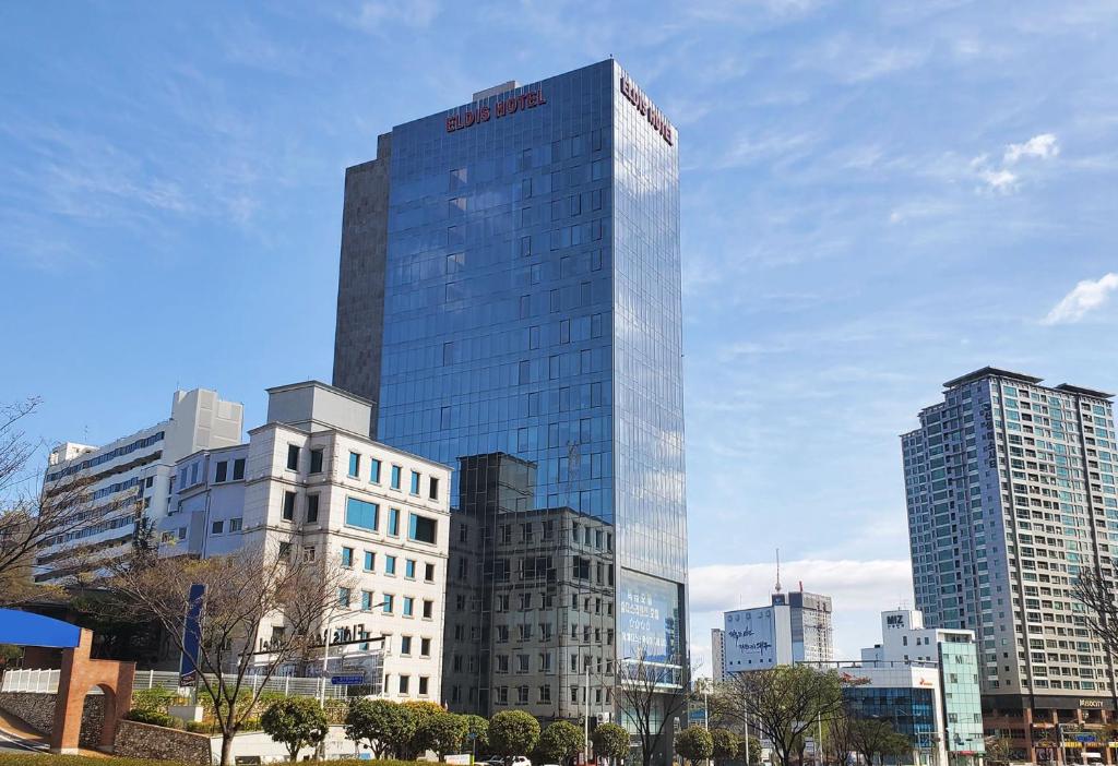 um edifício de vidro alto numa cidade com edifícios altos em Eldis Regent Hotel em Daegu