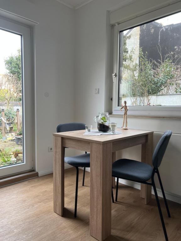 einen Tisch und Stühle in einem Zimmer mit Fenster in der Unterkunft Appartement am Teich in Krefeld