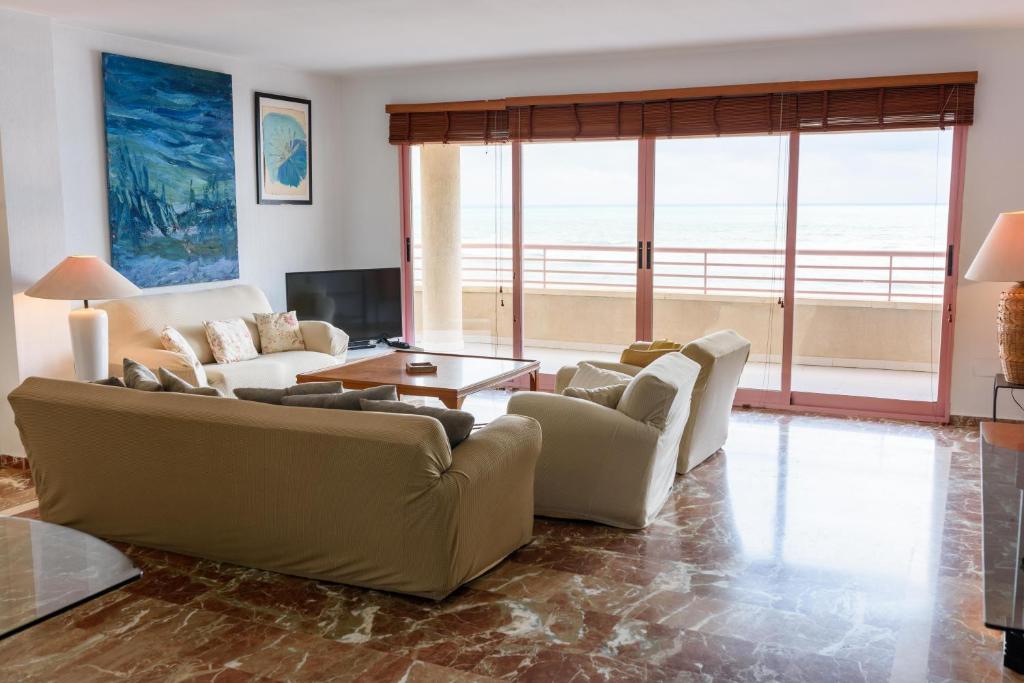 een woonkamer met een bank en een tafel bij Piso familiar frente al mar in Calpe