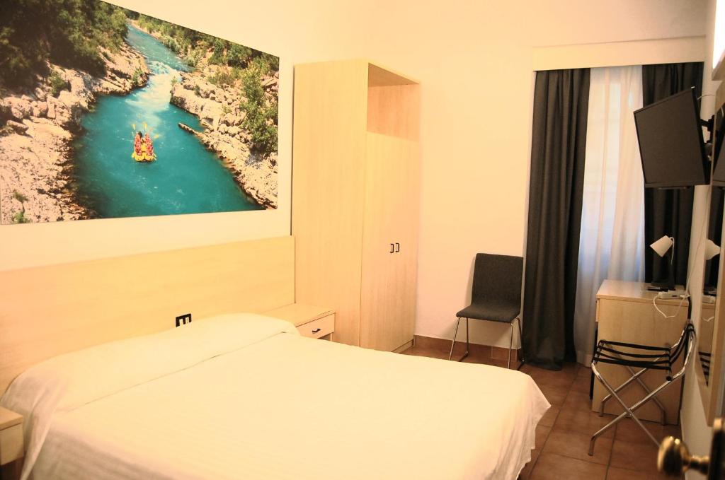 a hotel room with a bed and a painting on the wall at MA Hotel in Corinaldo