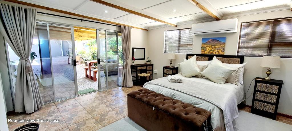 een slaapkamer met een bed en een glazen schuifdeur bij Mountain View Guesthouse in Vanrhynsdorp