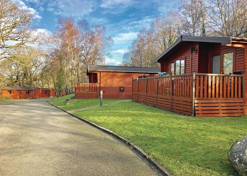 Ogwen Bank Caravan And Lodge Park في بيثيسدا: كابينة خشبية مع شرفة وممر