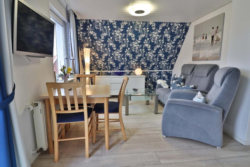 a living room with a dining room table and chairs at Kiek rin bi Kati - Ferienwohnung 2 in Langeoog