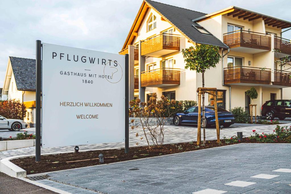 um sinal em frente a uma casa com um edifício em Pflugwirts Hotel und Gasthaus em Oberkirch