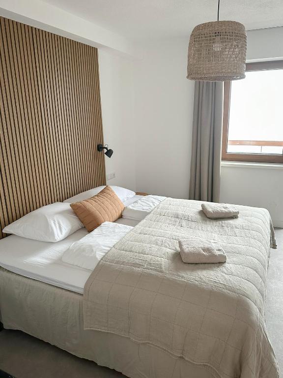 1 dormitorio con 1 cama blanca grande y ventana en Hotel Der Drahtesel, en Bramberg am Wildkogel