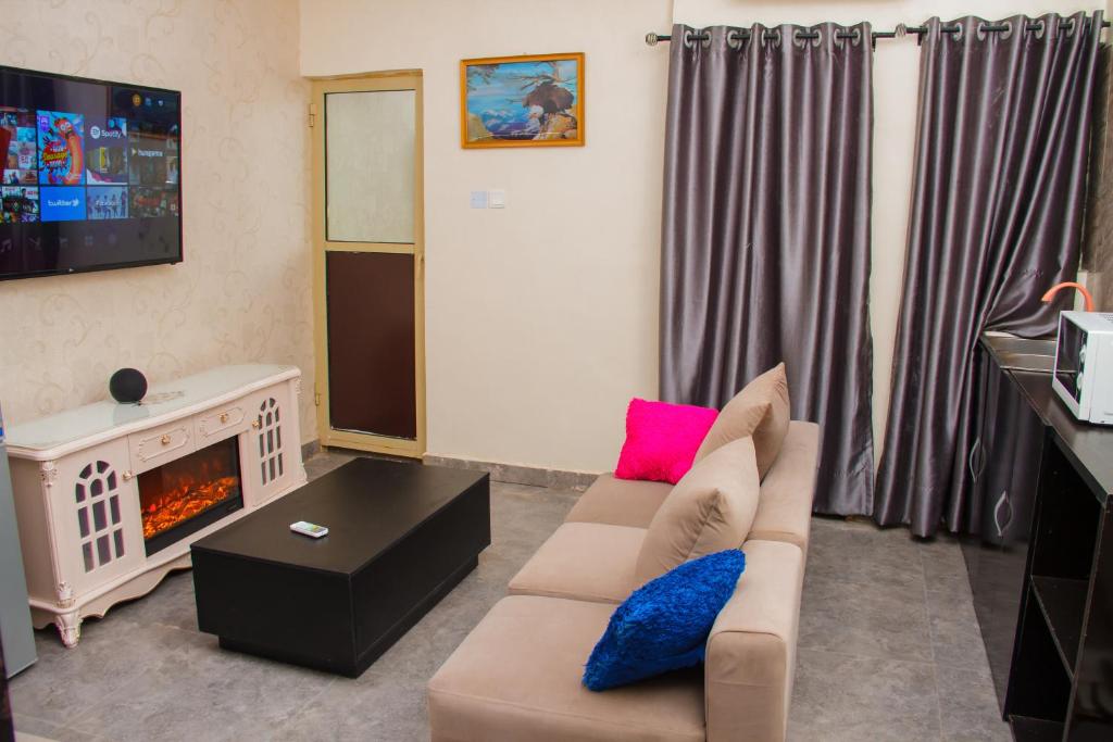 a living room with a couch and a fireplace at Go2Hotel45 in Lagos