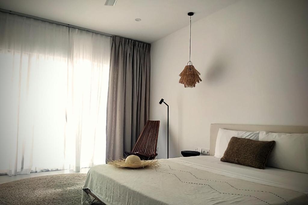 1 dormitorio con cama y ventana grande en Coco Villa, en Thoddoo