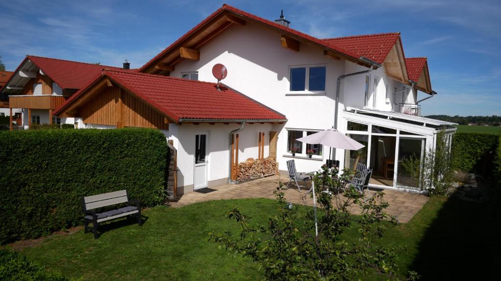 ein weißes Haus mit einer Bank im Hof in der Unterkunft Astara - Dein Traum-Ferienhaus in Schwangau in Schwangau