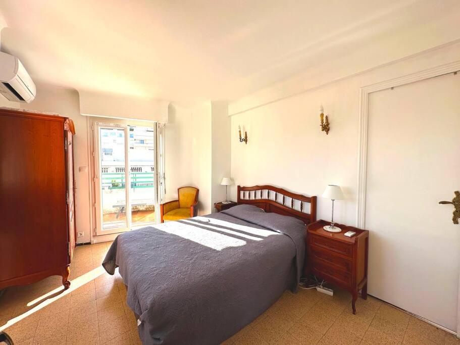um quarto com uma cama e uma janela em Viva Riviera Large 1 Bedroom with Sunny Terrace em Cannes