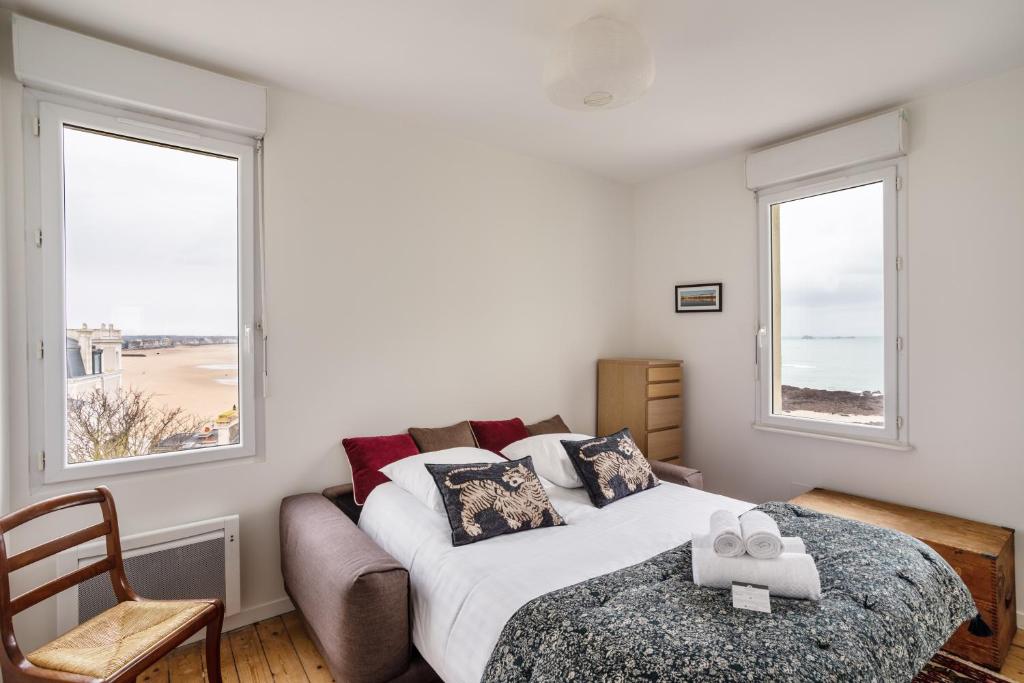 une chambre avec un lit et deux fenêtres dans l'établissement Le Beau Site - Proche plage parking privé, à Saint-Malo