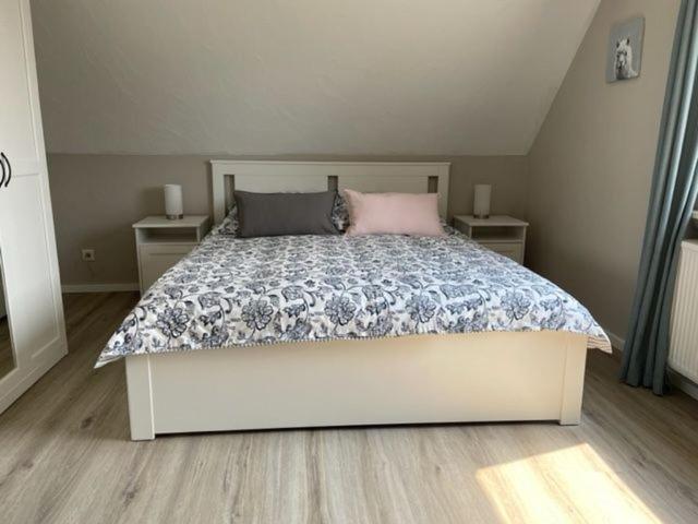 a bedroom with a large bed with two night stands at Ferienwohnung Eulennest in Drolshagen
