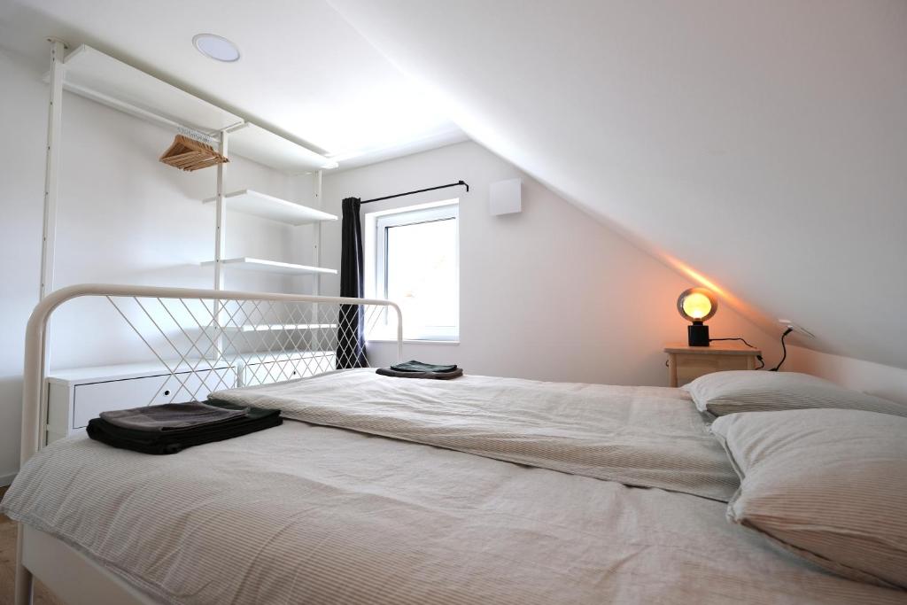 a white bedroom with a bed in a attic at Apartments Emona FREE Parking-sauna-gym in Ljubljana