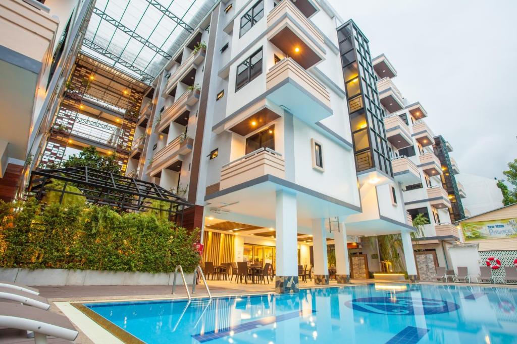 a building with a swimming pool in front of a building at New Siam Palace Ville Hotel - SHA Extra Plus Certified in Bangkok