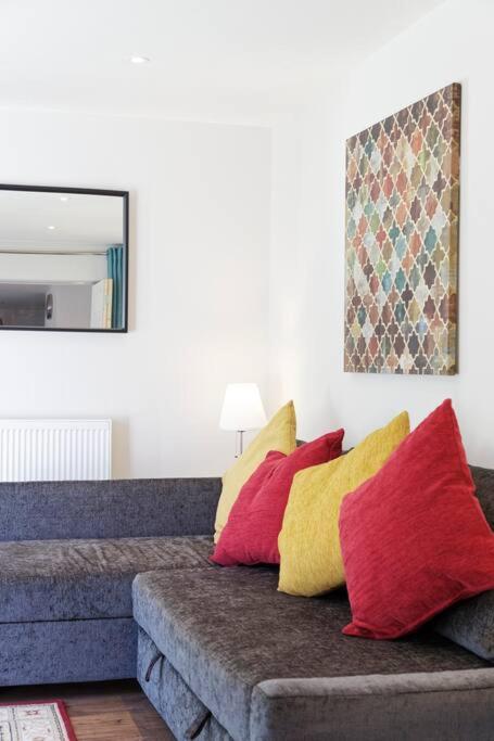a living room with a couch with colorful pillows at Garden Oasis in Margate