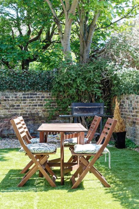 two chairs and a wooden table with a table and chairs at Garden Oasis in Margate