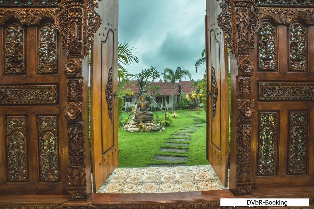 an open door with a view of a yard at Dayung Villas By Reccoma in Nusa Lembongan