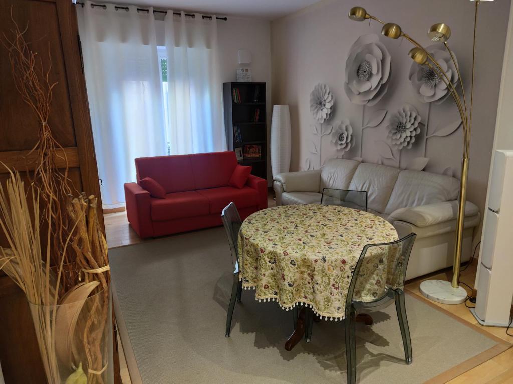 uma sala de estar com uma mesa e um sofá vermelho em Appartamento EmmeRosa, centro città, parcheggio em Verona