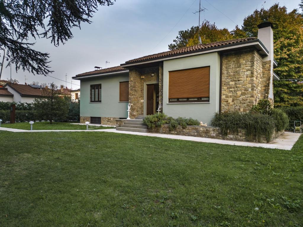 a brick house with a brown door and a yard at Villa Cantoni in Castelfranco Emilia