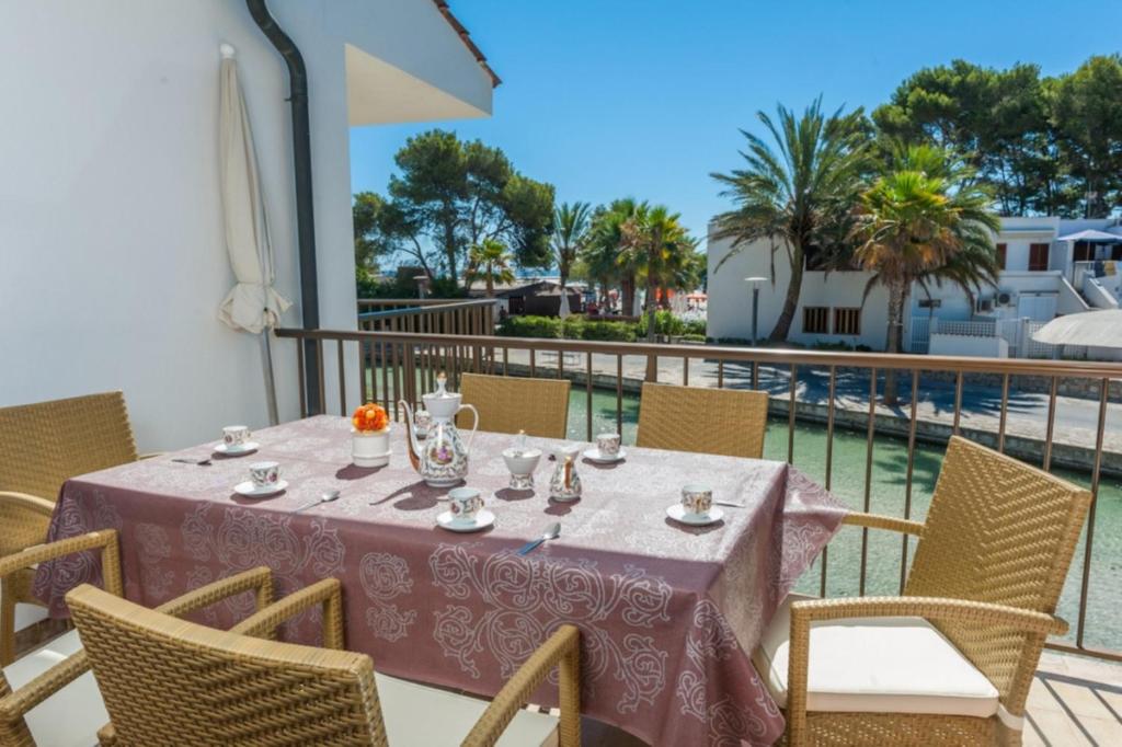 einen Tisch auf einem Balkon mit Poolblick in der Unterkunft Gran Canal in Alcúdia